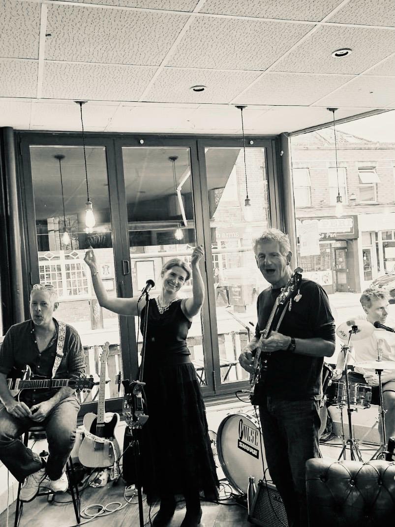 Black and white photo of the band with the singer raising her arms